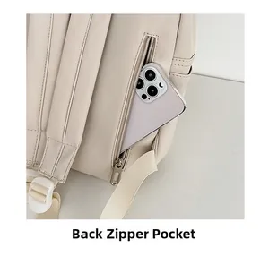 Detail of rear anti-theft zipper pocket on cream white backpack for secure storage