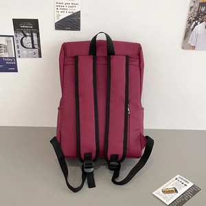Detailed back view of burgundy minimalist backpack with padded straps and zipper