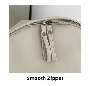 Close-up of smooth double zipper with stylish pullers on beige minimalist backpack