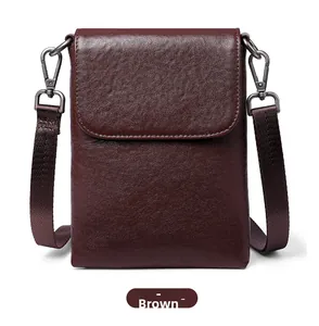 Detailed close-up of brown textured leather phone bag with magnetic flap and metal hook