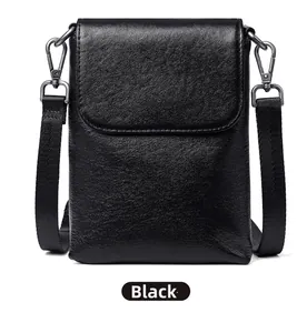 Detailed view of the black vegetable-tanned leather phone bag with wide woven strap