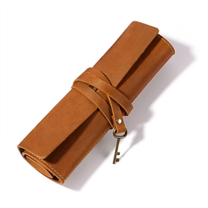 Detailaufnahme der braunen Vintage-Leder-Stifterolle mit antikem Schlüssel-Anhänger
