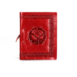Detailed close-up of vintage red leather notebook with embossed rose and Celtic patterns