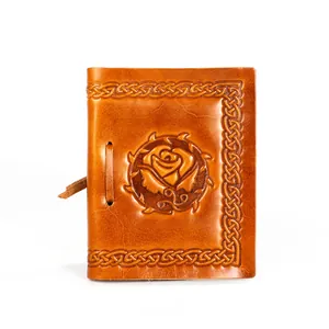 Detail of embossed rose and Celtic patterns on handmade vintage brown leather journal