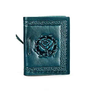Detail of embossed teal leather journal with rose carving and celtic knot border