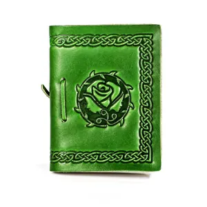 Macro detail of green leather notebook with embossed vintage rose and Celtic knot border
