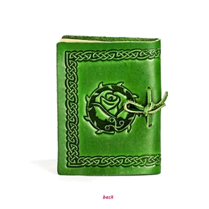 Close-up of the vintage dark green leather notebook with embossed rose and Celtic knot back