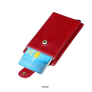 Detail of red leather wallet interior with automatic pop-up aluminum card holder and button