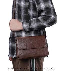 Close-up of brown vegetable tanned leather messenger bag with detailed pebble grain texture