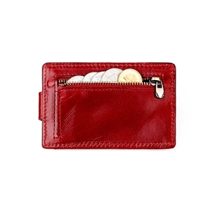 Detail view of red leather wallet zipper pocket with coins showing storage capacity