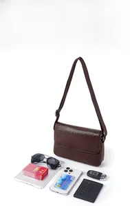 Detail shot of a brown pebbled leather crossbody bag showing internal storage capacity
