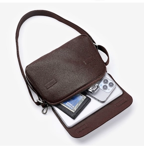 Detail view showing interior pockets and spacious main compartment of leather messenger bag