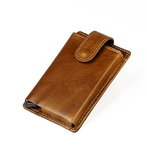 Detail view of brown leather wallet with automatic pop-up aluminum card holder and snap closure