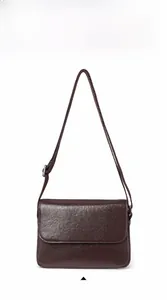 Front view of a dark brown vegetable-tanned leather crossbody bag with a pebble grain texture