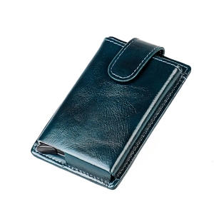 Close-up of a dark teal leather wallet showing the card pop-up mechanism and texture
