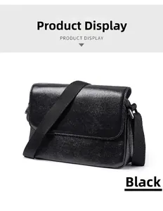 Detail view of the black vegetable-tanned leather crossbody bag with adjustable strap