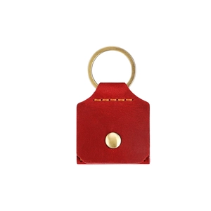 Détail de la pochette à bijoux en cuir rouge avec bouton pression doré et coutures jaunes