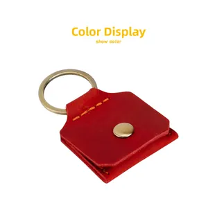 Detail of red genuine leather keychain pouch with metal snap button and contrast stitching
