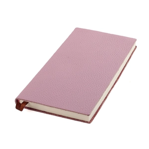 Gros plan d'un carnet en cuir grainé rose-violet avec un marque-page en ruban de soie