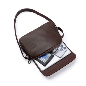Dark brown vegetable tanned leather messenger bag showing spacious iPad and phone interior