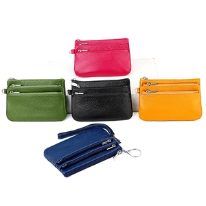 Detailed view of five colorful leather coin purses with triple zippers and wrist straps