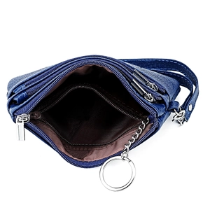 Detail view of the multi-layer interior compartments and silver keychain in a blue leather bag