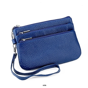 Detail view of navy blue pebbled leather wristlet with three zipper pockets and silver hardware