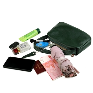 Detail showing high storage capacity of green pebbled leather bag with daily essentials
