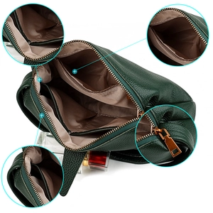 Detail view of green pebbled leather bag interior with multiple compartments and gold hardware