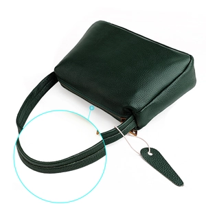 Close-up of green lychee grain leather handbag showing high-quality stitching detail