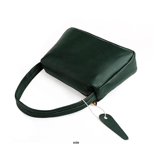 Side view of dark green pebbled leather shoulder bag showing zipper and hanging tag