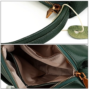 Detail of dark green pebble leather bag showing interior lining and bronze zipper pocket