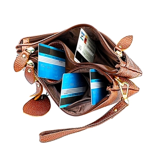 Internal view of brown leather crossbody bag with three zipper pockets and card slots