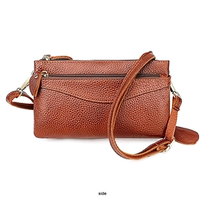 Side view of brown lychee grain leather crossbody bag with multiple zippers and adjustable strap