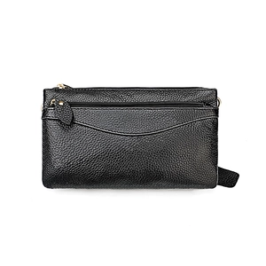 Macro detail of high-quality pebbled leather texture and golden metal zippers on the black bag