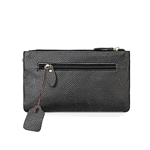 Detail of black lychee-textured leather bag with double metal zippers and tassel charm