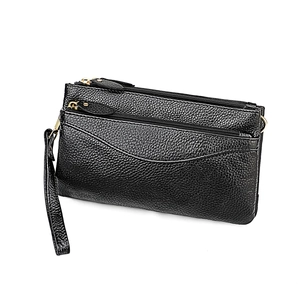 Detail of black lychee grain leather clutch with gold metal zipper and wrist strap