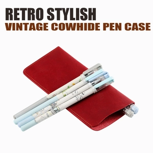 Close-up of retro dark red cowhide glasses case with yellow stitching and pens inside