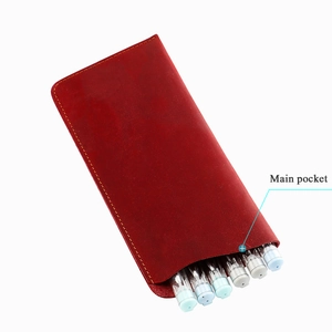 Detail of red crazy horse leather eyewear pouch with precise yellow stitching and main pocket