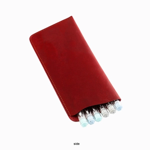 Detail view of red crazy horse leather sunglasses pouch with yellow stitching and wave cut edge