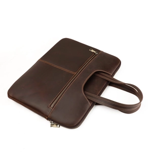 Detail view of crazy horse leather laptop bag with bronze zippers and reinforced handles