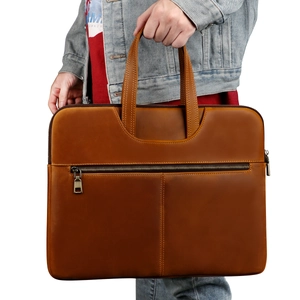 Detail of genuine brown leather laptop bag with double handles and front zipper pocket
