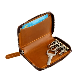 Interior of dark brown leather key pouch showing six copper hooks and a built-in card slot