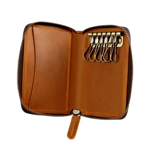 Detail view of brown leather key case interior with six vintage metal hooks and card slot