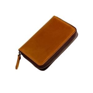 Detailed close-up of brown genuine leather texture and stitching on zipper key pouch