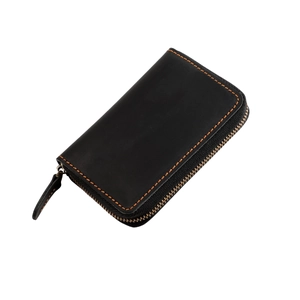 Detail of genuine leather keychain pouch with vintage texture and orange hand-stitched seams