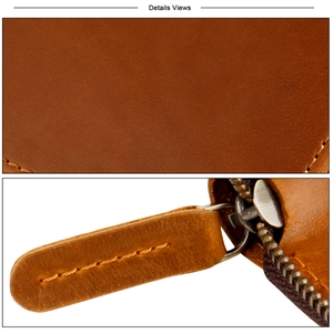 Detailed macro view of retro brown leather texture and stitching on a zipper key pouch