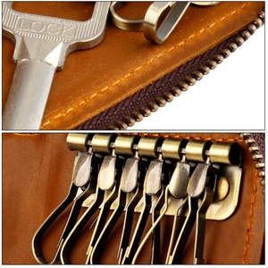 Macro detail of brown leather car key bag with six vintage bronze metal hooks and stitching