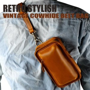 Detail of vintage cowhide phone bag showing genuine leather texture and stitching on belt