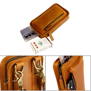 Detail of vintage brown leather phone holster with bronze hardware and belt loop